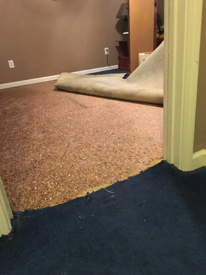 Carpet pad removal revealing water damage during Water Mitigation Services in Cumming
